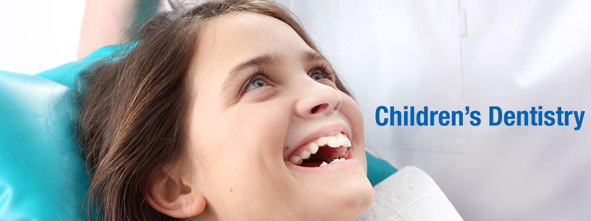 children's dentistry - child sitting on a dentist chair and smiling